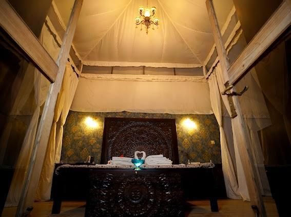 Canopy bed with chandelier inside a heritage-style desert tent